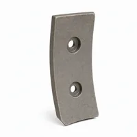 Curved grey blast wheel blade with two mounting holes on white background