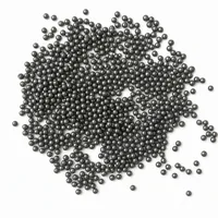 Close-up macro photograph of a mound of spherical Cast Steel Shot abrasive media on a white background