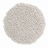 Mound of off-white ceramic beads blasting media on white background