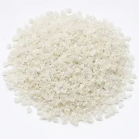 Mound of angular off-white plastic abrasive 220 mesh particles on white background