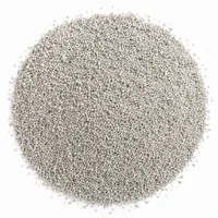Close-up of a mound of off-white, porous Pumice Grit 46 mesh abrasive media on a white background.