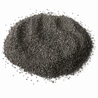 Mound of angular dark grey steel grit abrasive media on white background